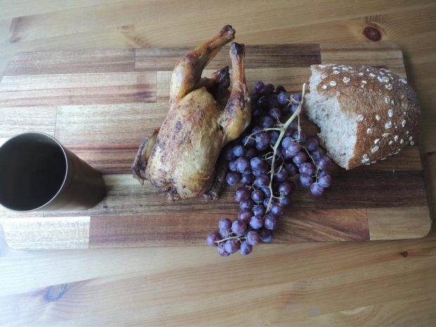 Pollo rostizado, pan, uvas y cerveza.