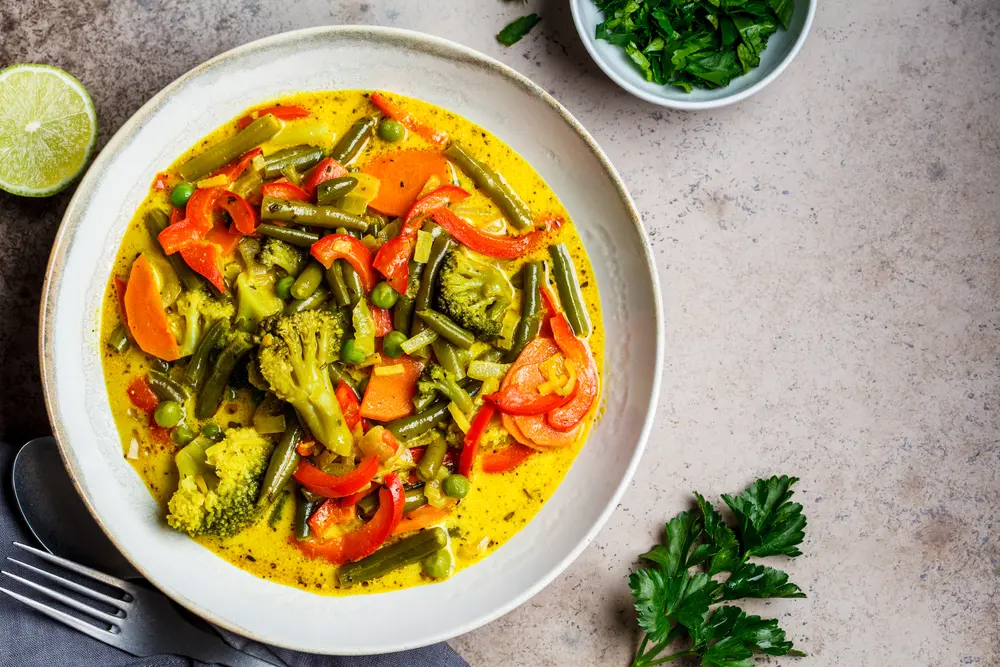 Prepara una receta de verduras al curry vegano con boniato, calabaza, calabacín y champiñones.