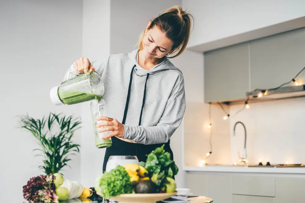 La estrecha relación entre la nutrición y el sistema digestivo / mujer desayunando un jugo verde