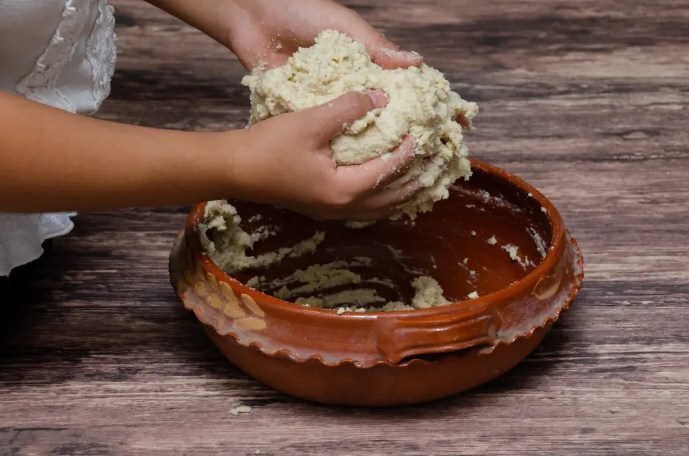 Manos con masa de maiz nixtamalizado, cocina tradicional mexicana