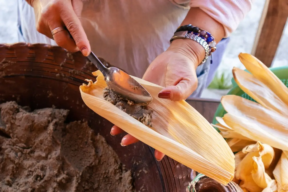Preparar tamales en la hoja de maíz, untado