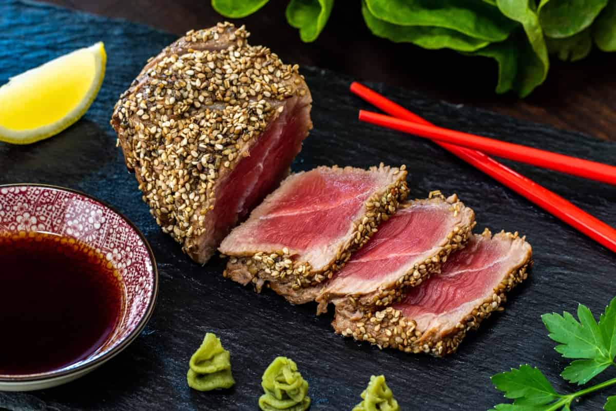 Dentro de la versatilidad de las recetas de atún, también puedes preparar una variación como el tataki de atún con costra de ajonjolí con salsa oriental. / Foto: Shutterstock