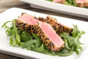 Dentro de la versatilidad de las recetas de atún, también puedes preparar una variación como el tataki de atún con costra de ajonjolí con salsa oriental. / Foto: Shutterstock