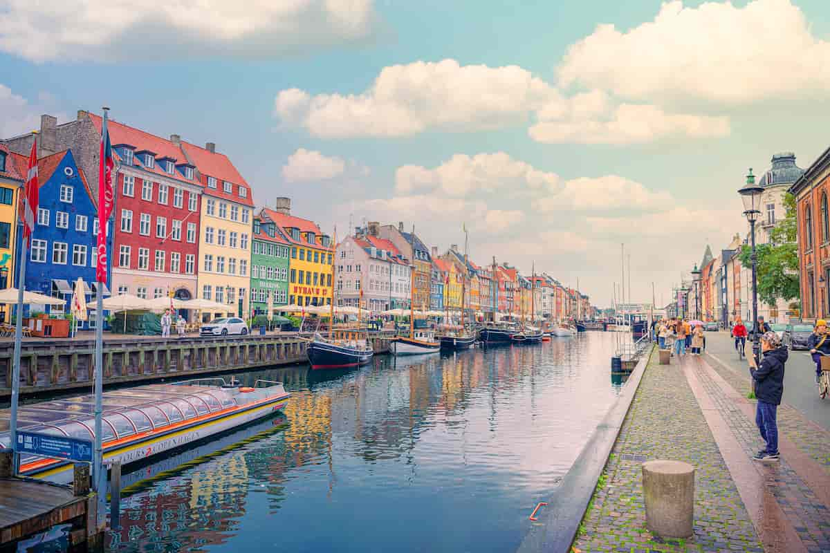 Calle Nyhavn, un lugar popular para caminar con muchos barcos y casas coloridas en Copenhague