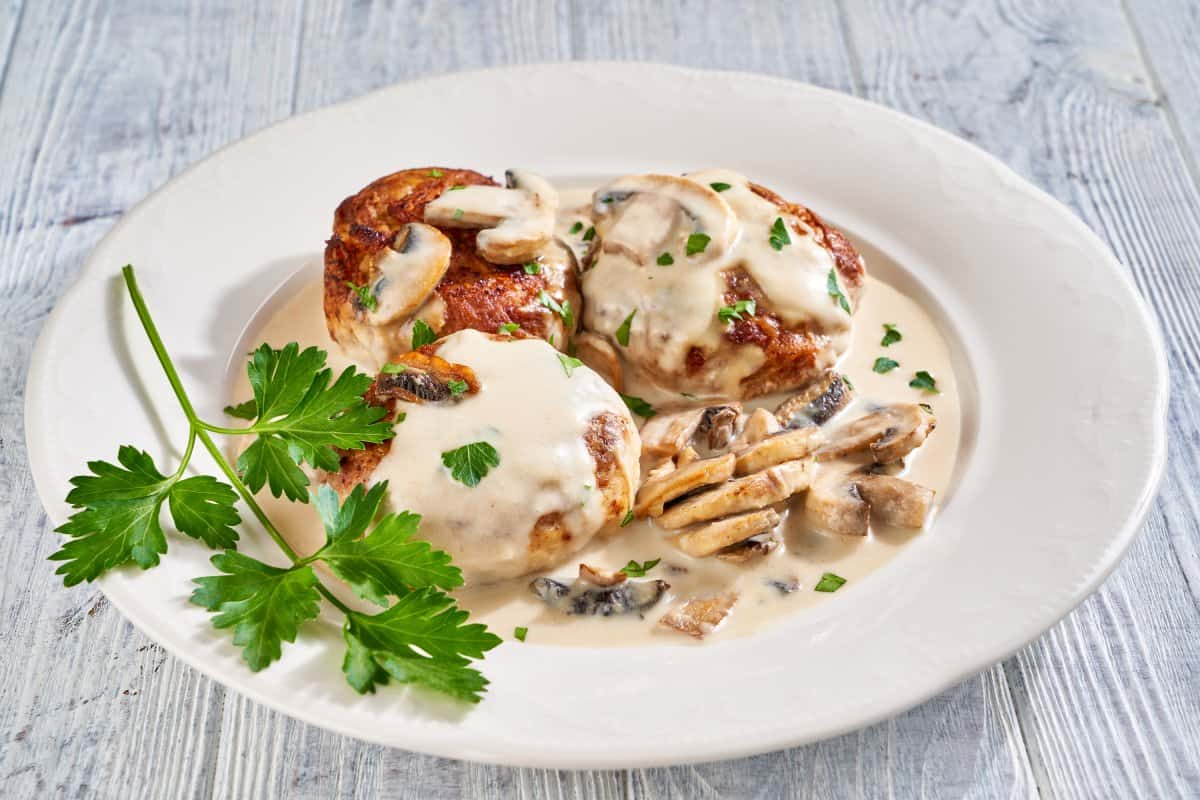 Pollo relleno de vegetales en salsa de champiñones